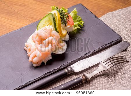 Danish specialties and national dishes high-quality open sandwich. Boiled Egg Shrimps mayo cucumber and lemon served on a plate and ready for eating
