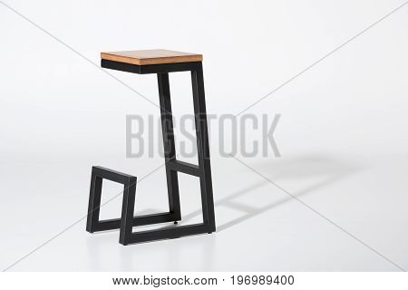 Studio Shot Of Stylish Barstool With Wooden Top And Black Metallic Legs Standing On White