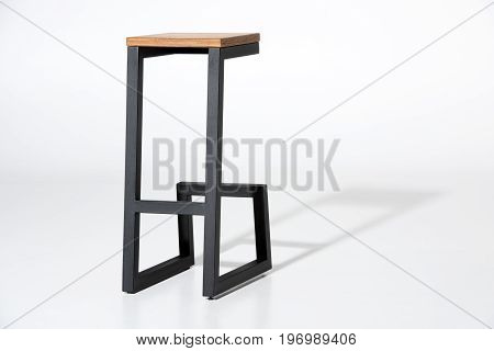 Studio Shot Of Stylish Barstool With Wooden Top And Black Metallic Legs Standing On White
