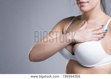 Woman in white push up bra on gray background perfect female breast studio shot