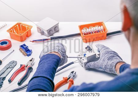 Electrician Working On Electrical Panel. Service Electrical Equipment.