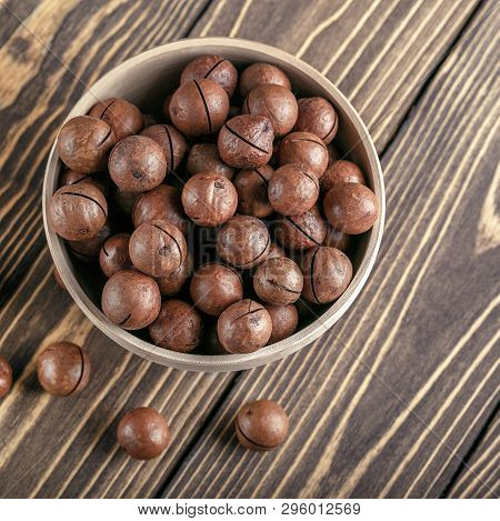 Macadamia Nuts In Bowl On A Wooden Table. Top Wiew.