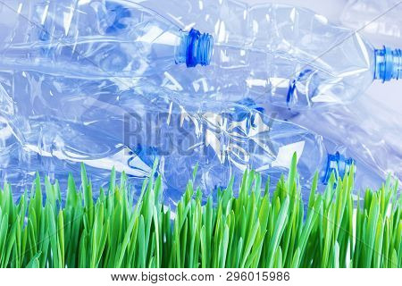 Flattened Plastic Bottles Ready For Recycling On Green Grass. Plastic Pollution Problem Concept.