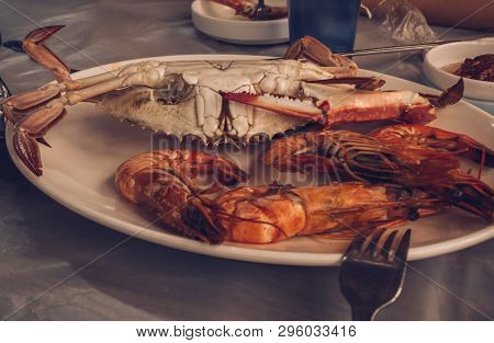 Close Up View Of Boilled Shrimps And Crab On Plate In Natural Cafe Environment
