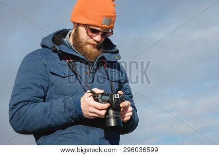 Close-up Portrait Bearded Male Photographer In Sunglasses With Dslr Camera In His Hands Looks At The