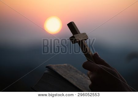 Hands Holding Wooden Cross Over Open  Holy Bible On The Mountain Background With Morning Sunrise, Sp