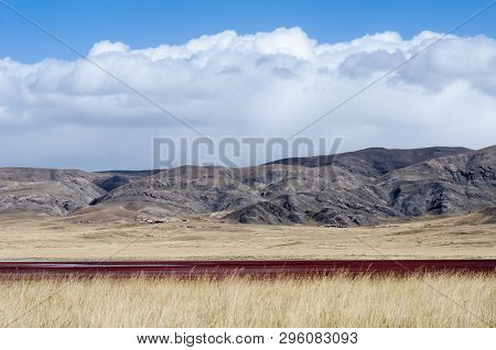 Tibetan Highlands And Interesting Red-colored Lake Near Daotanghe City At Qinghai Province