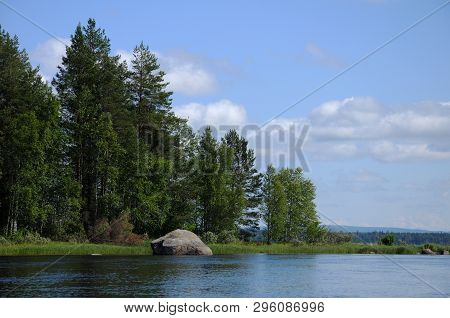 The Beautiful Picture Of Karelian Forest At The Edge Of A Lake, And Some Huge Boulder In This Lake