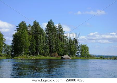 The Beautiful Picture Of Karelian Forest At The Edge Of A Lake, And Some Huge Boulder In This Lake