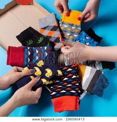 Socks Of Different Colors Are In A Pizza-shaped Box, Womens Hands Take Socks And Show An Affirmative