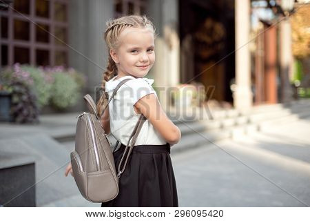 Happy Smiling Girl Is Going To School For The First Time With Bag Go To Elementary School. Pupil Go 