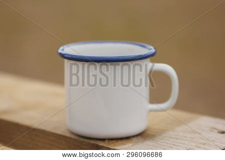 A White Coffee Mug On A Wooden Surface. Picnic Outdoors.
