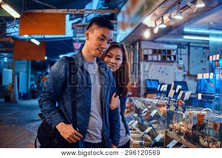 Happy Asian Couple Looking For Something Special At Chainese Market. They Are Pensive. A Lot Of Seaf