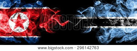 North Korea Vs Botswana, Botswanan Smoky Mystic Flags Placed Side By Side. Thick Colored Silky Smoke