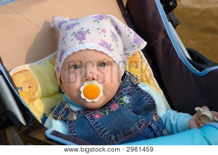 Holčička s dětská figurína sedí v kočáře.
