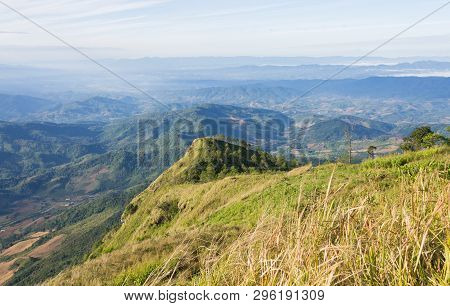 Phu Nom At Phu Langka National Park With Yellow Sun Light. Phu Nom Mountain With Grass Field Green T