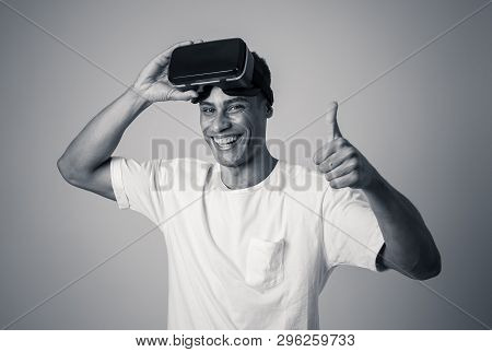 Portrait Of Cheerful Young Man Wearing Virtual Reality Goggles For First Time Smiling At Camera