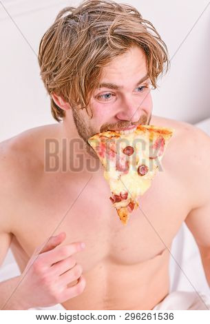 Man Bearded Handsome Bachelor Eating Cheesy Food For Breakfast In Bed. Handsome Man Holds A Piece Of