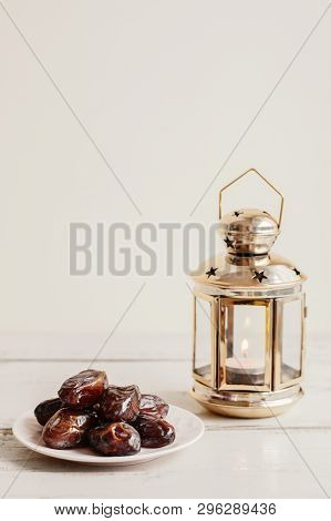 Dried Dates And Gold Colored Lantern With Burning Candle On Wooden Table. Traditional Sweet Food Dur