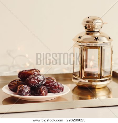One Portion Of Dried Dates And Gold Colored Lantern With Burning Candle On Metal Tray. Ramadan Karee