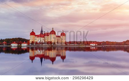 Splendid Morning Scene. Moritzburg Castle Near Dresden With Colorful Sky During Of Sunrise, Reflecta