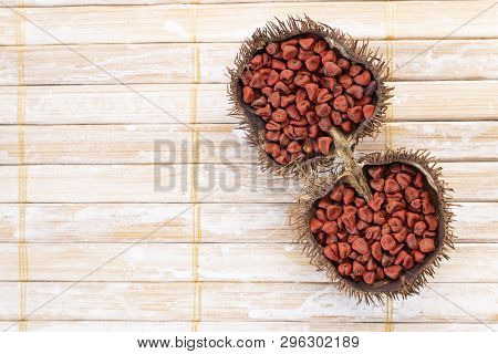 Annatto Seeds On Rustic Wood