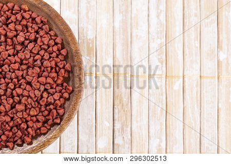 Annatto Seeds On Rustic Wood