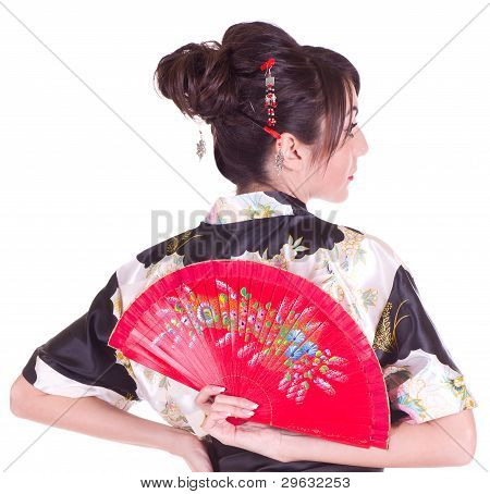 Beautiful young woman in Asian costume with red Asian fan