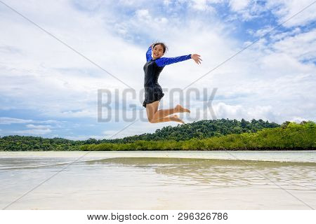 Happy Asian Teen Girl Wearing A Swimsuit Jumping Fun On The Beach Of Ko Ra Wi Under The Blue Sky Dur