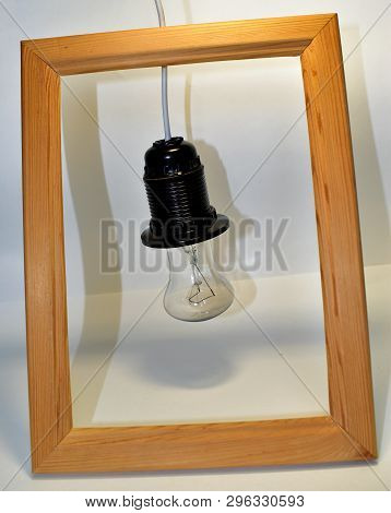 Old Light Bulb On Short Wire In Wooden Frame