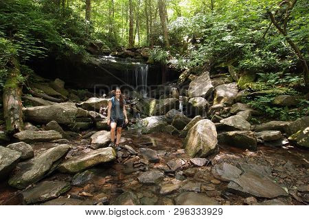 Young Woman Explores A Small Trailside Waterfall In The Great Smoky Mountains National Park, Tenness