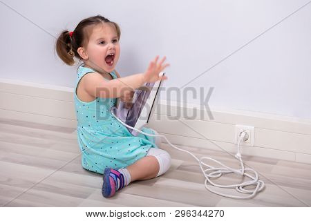 Cute Toddler Girl Screaming After Touching Hot Iron Plugged In Outlet. Crying For Help