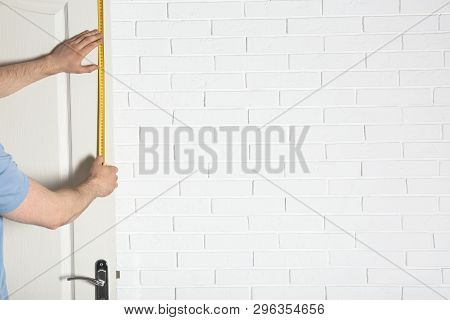 Man Measuring Door In Room. Construction Tool