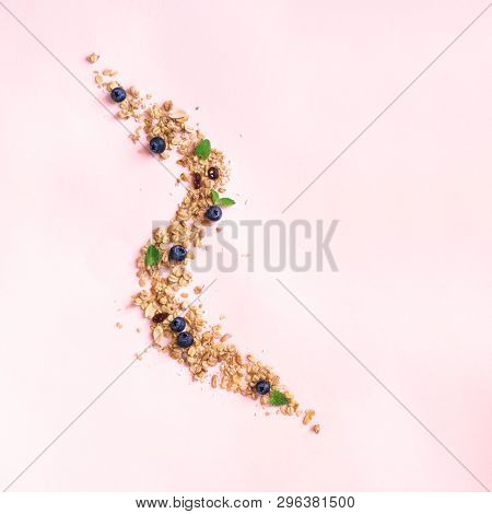 Homemade Granola On Spoon With Bluberries On Pink Background, Copy Space. Healthy Snack Or Breakfast
