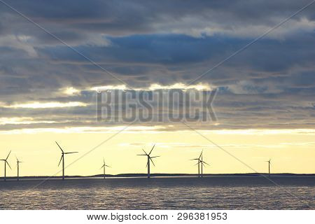 Sunset Over A Windmill Farm In A Large Lake In Sweden.
