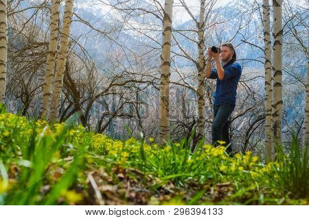 A Man Shoots A Photo In The Spring Birch Forest