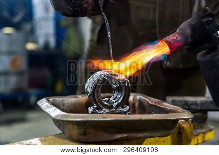 Professional Male Worker Using A Gas Torch To Melt Lead Metal. Close-up A Gas Burner With A Fire Aim