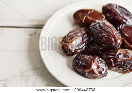 Dried Dates On White Plate. Healthy Snack. Traditional Dessert During Ramadan Month