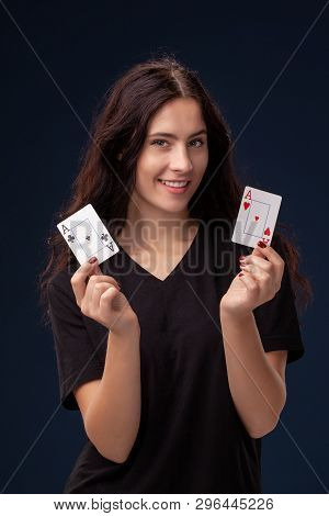 Close-up Shot Of Curly Hair Brunette Posing With Playing Cards In Her Hands. Poker Concept On A Blac