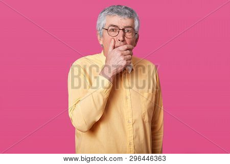 Close Up Portrait Of Man With Black Rounded Glasses, Dressed Yellow Shirt And Bow Tie. Eldery Senior