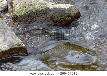 Smooth Water Flowing Over Rocks. Long Exposure Image Of River Water Flowing Over And Between Rocks