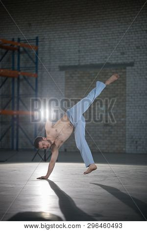 An Athletic Man On Capoeira Training About To Perform A Flip