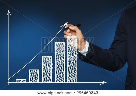 Businessman Drawing Efficiency Graph On Virtual Screen Against Color Background, Closeup