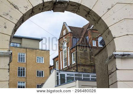 Brick Multi-level House With Large Beautiful Windows. Picture Taken Through The Old Arch. Central Lo