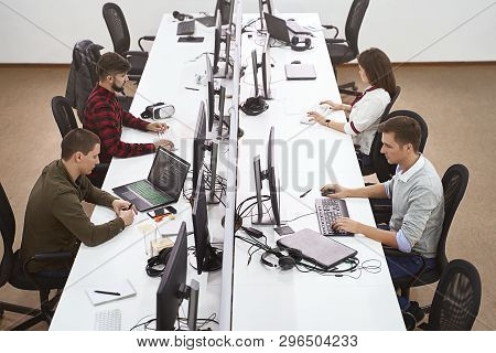 Young Professionals Working In Modern Office. Group Of Developers Or Programmers Sitting At Desks Fo