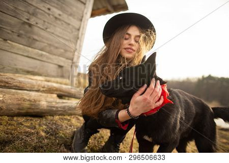 Happy Young Woman Plaing With Her Black Dog Brovko Vivchar In Fron Of Old Wooden House