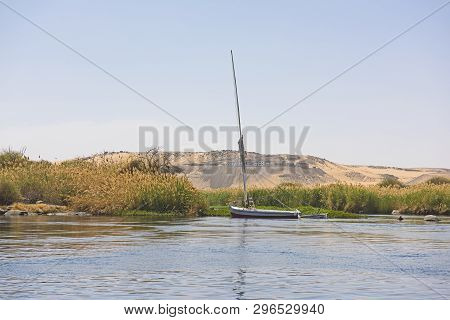 Sailing Down Large Wide River Nile In Aswan Egypt Through Rural Countryside Landscape With Rocky Cat