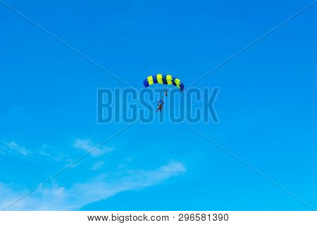 Male Skydiver Flies Under The Wing Of The Parachute, Descending And Coming In To Land Closer To The 