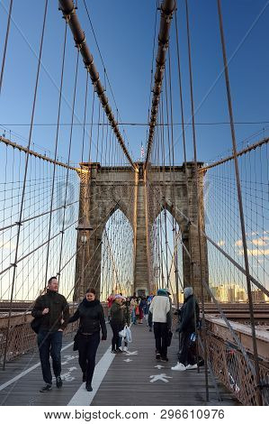 New York, Usa - 21 October 2018: Pedestrians Walk Over The Brooklyn Bridge At Sunset. Brooklyn Bridg