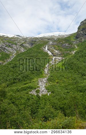 Melting Briksdal Glacier In Norway. Scenery Waterfall In Briksdal Glacier In Norway. Beautiful Water